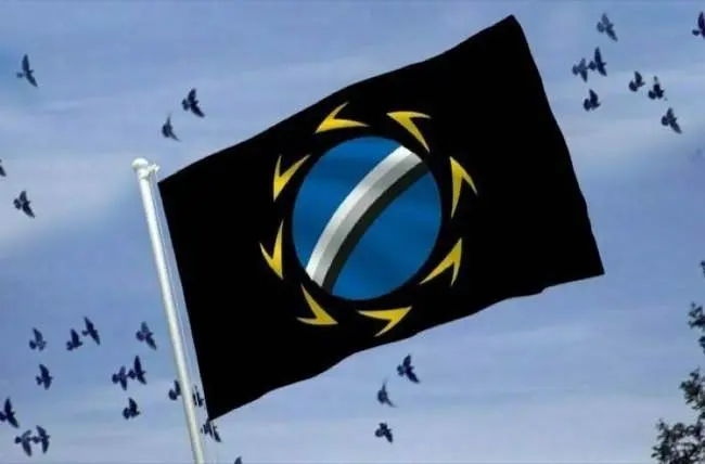A flag featuring a blue circle with a diagonal white stripe and yellow arrows is waving against a sky filled with flying birds.
