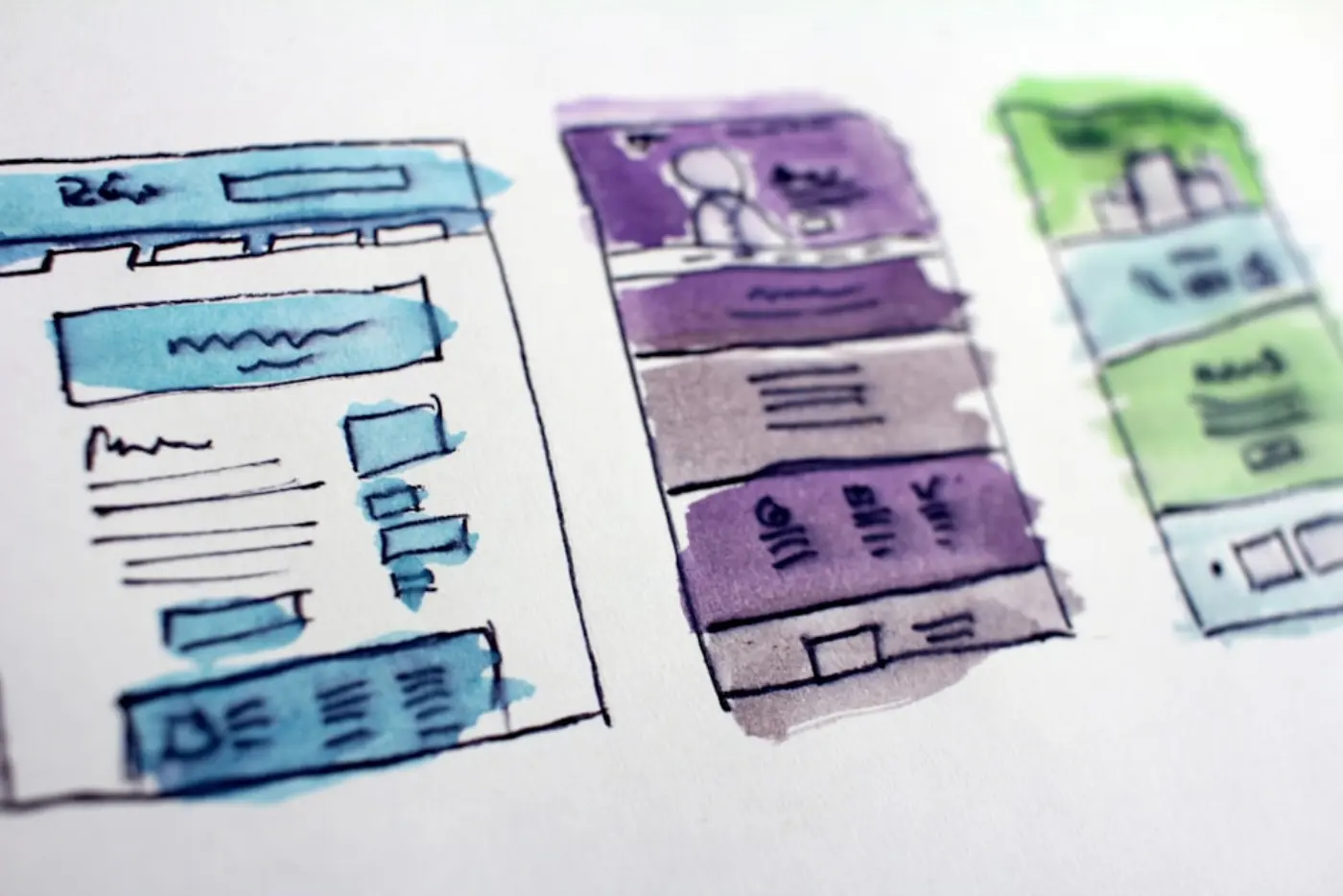 Sketches of websites coloured with watercolour paints
