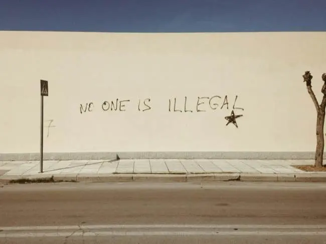 Grafitti saying 'no one is illegal'.