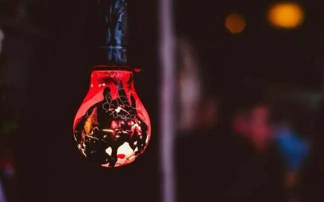 An old red bulb hanging amongst the rafters at Copenhagen Street Food Market.