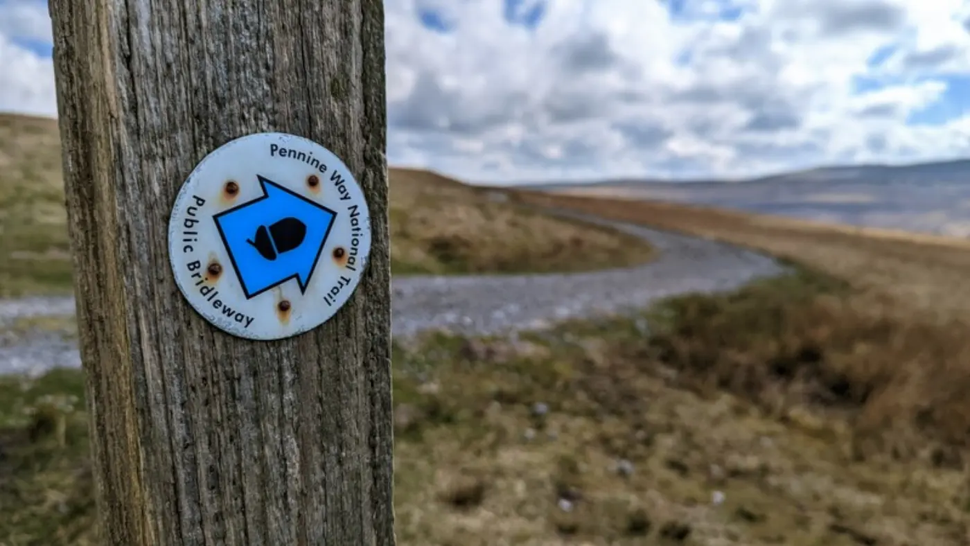 Pennine Way signpost with landscape in background