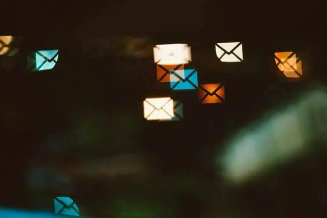Auto-generated description: Colorful envelope icons are scattered across a dark background, giving the appearance of floating lights.