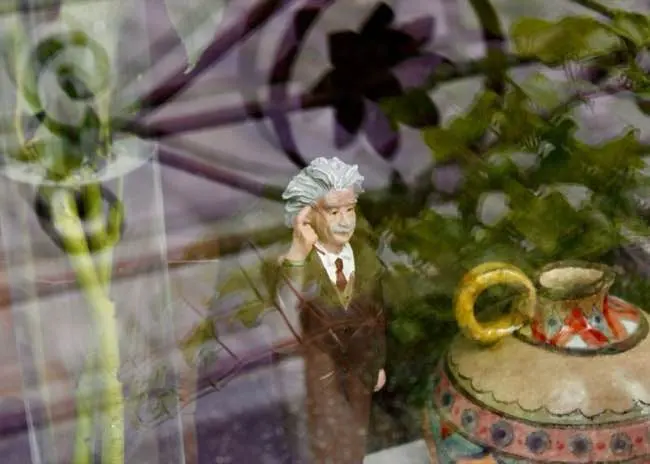 Looking through a window at an Albert Einstein figurine