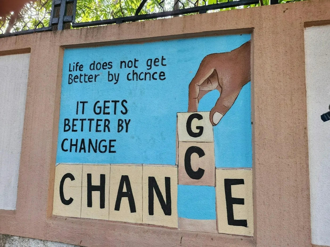 Mural in Mumbai, India, reading 'Life does not get better by chance, it gets better by change'
