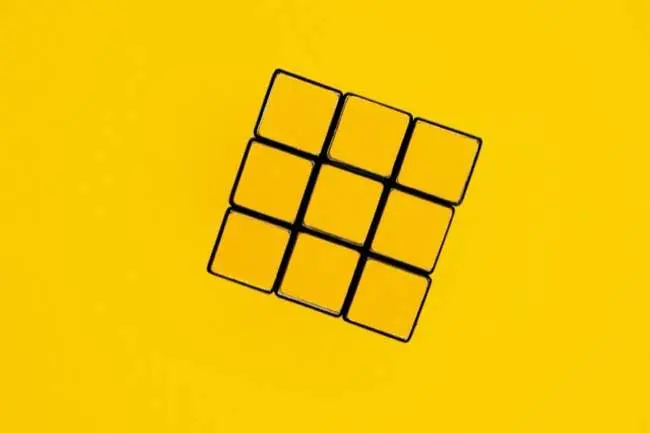 Yellow side of a solved Rubik's cube on a yellow background