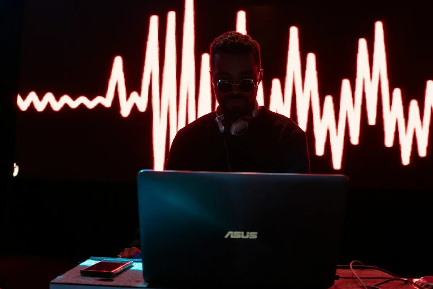 Man working on laptop in front of a hearbeat-style graph