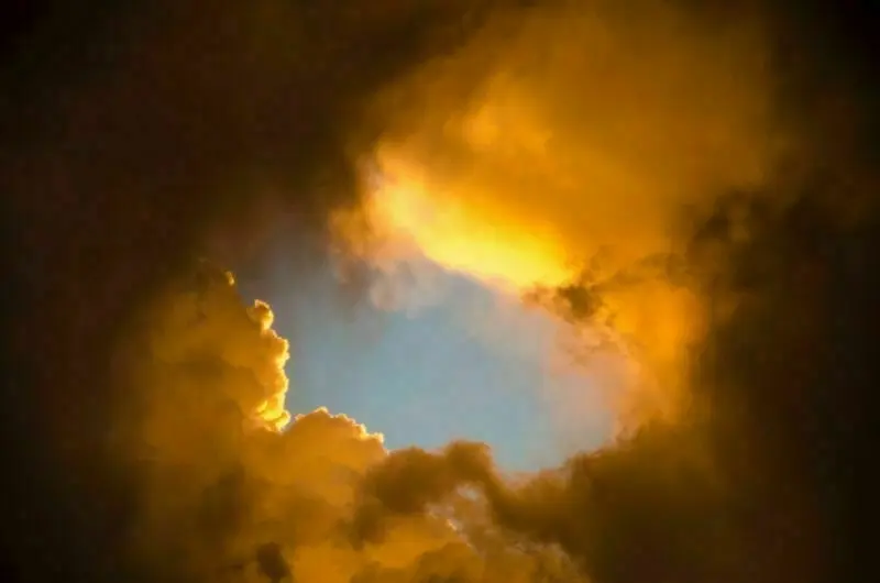 Blue sky through dark clouds