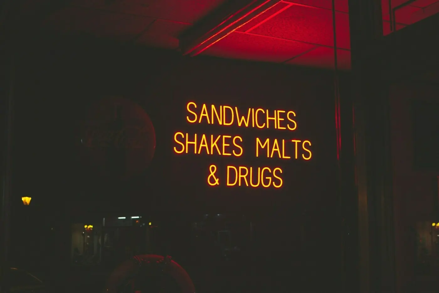 Black and red sign saying SANDWICHES SHAKES MALTS & DRUGS