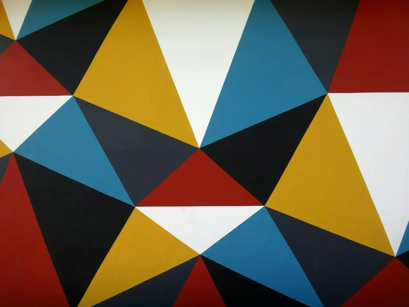 Auto-generated description: A geometric pattern composed of various colored triangles including blue, red, yellow, black, and white.